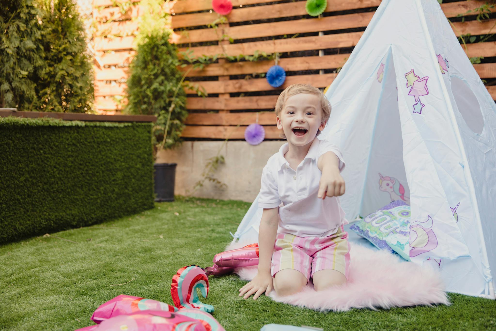 A joyful child enjoying an outdoor birthday party in a backyard setting.