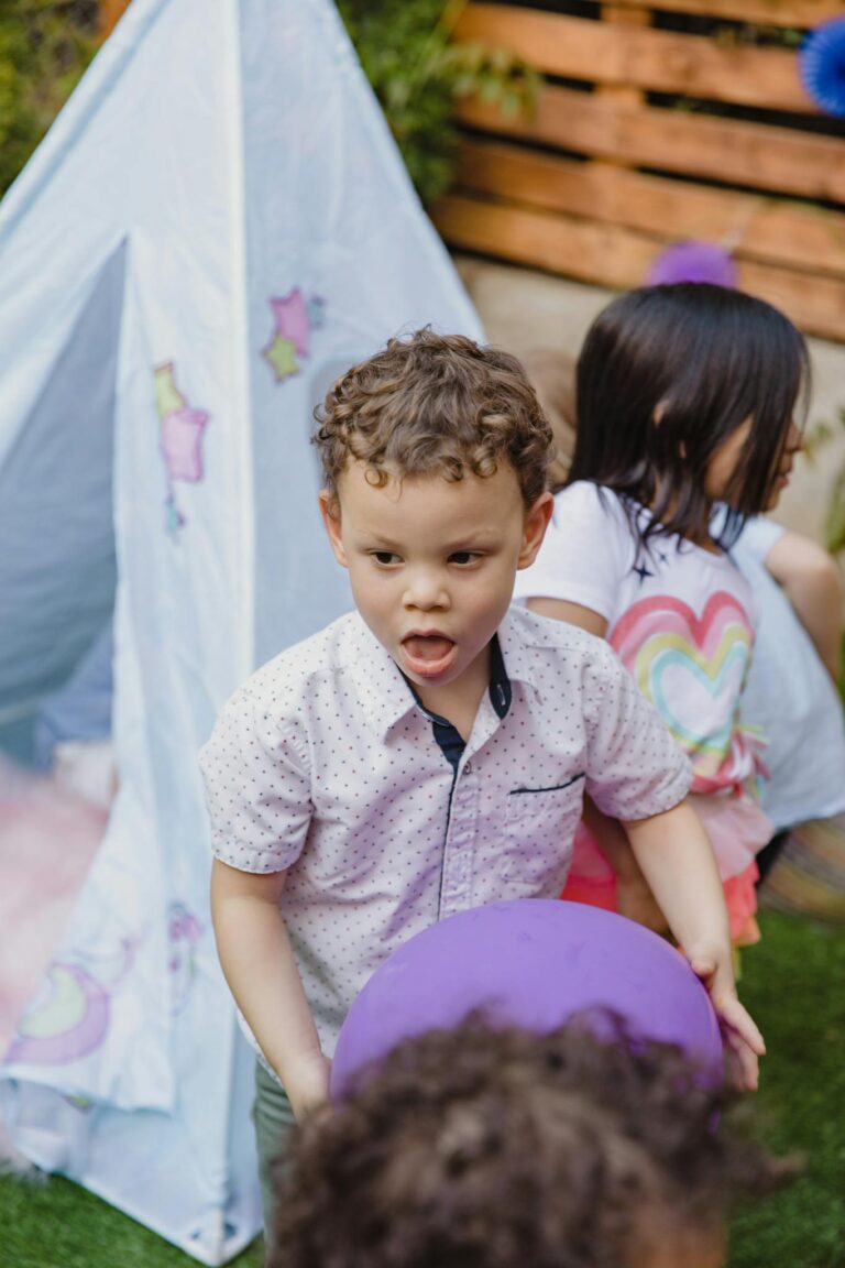 Children enjoying an outdoor birthday party with colorful decorations and playful activities.